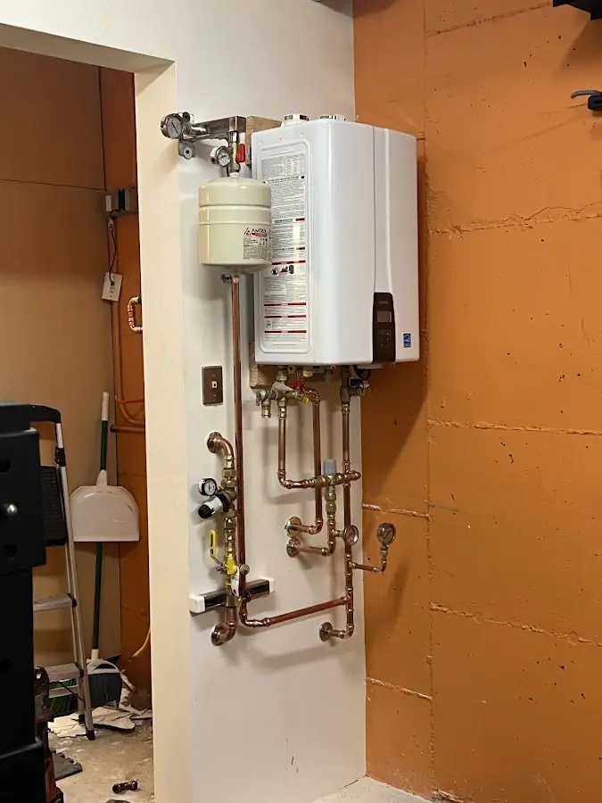 Plumbing technician inspecting water heater connections in Colonial Beach